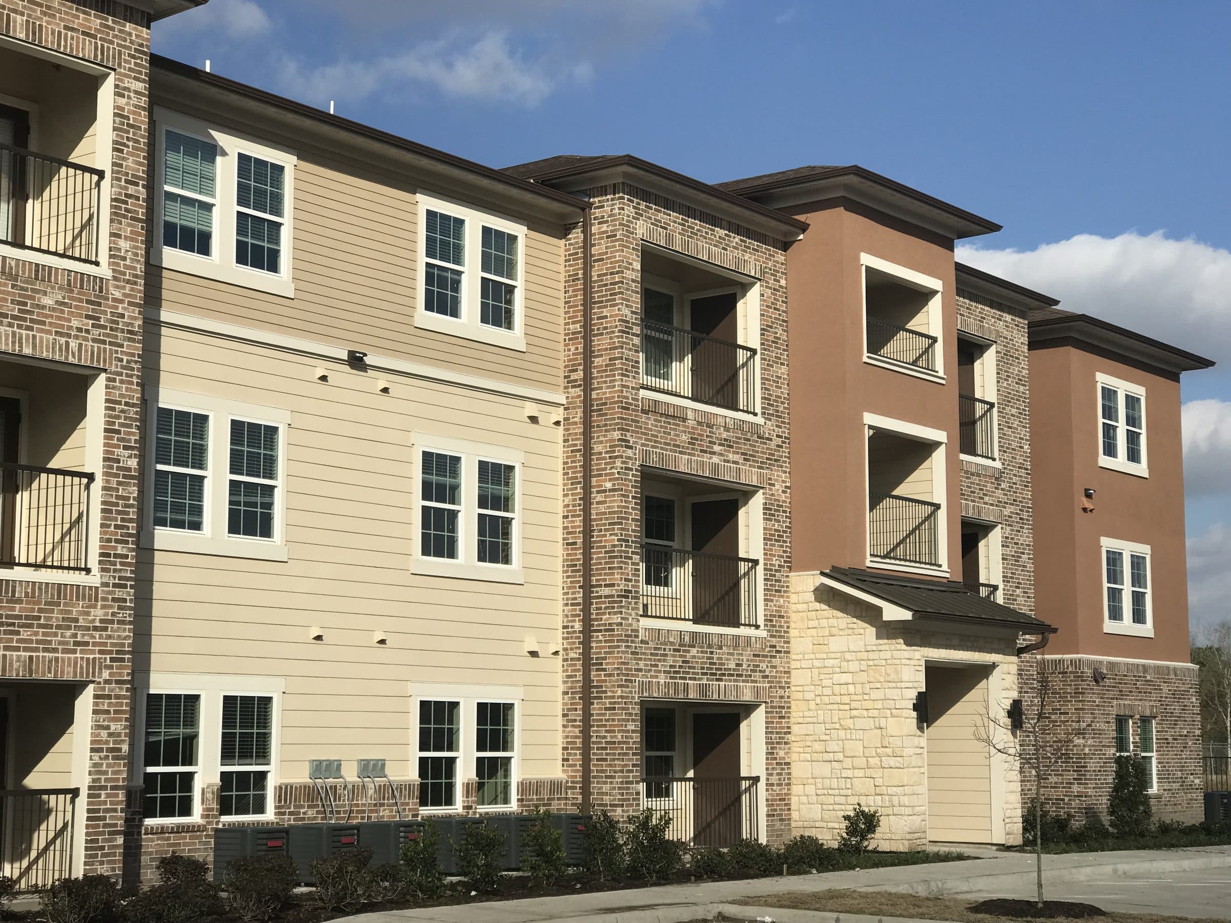 The completed three-story brick and siding elevation