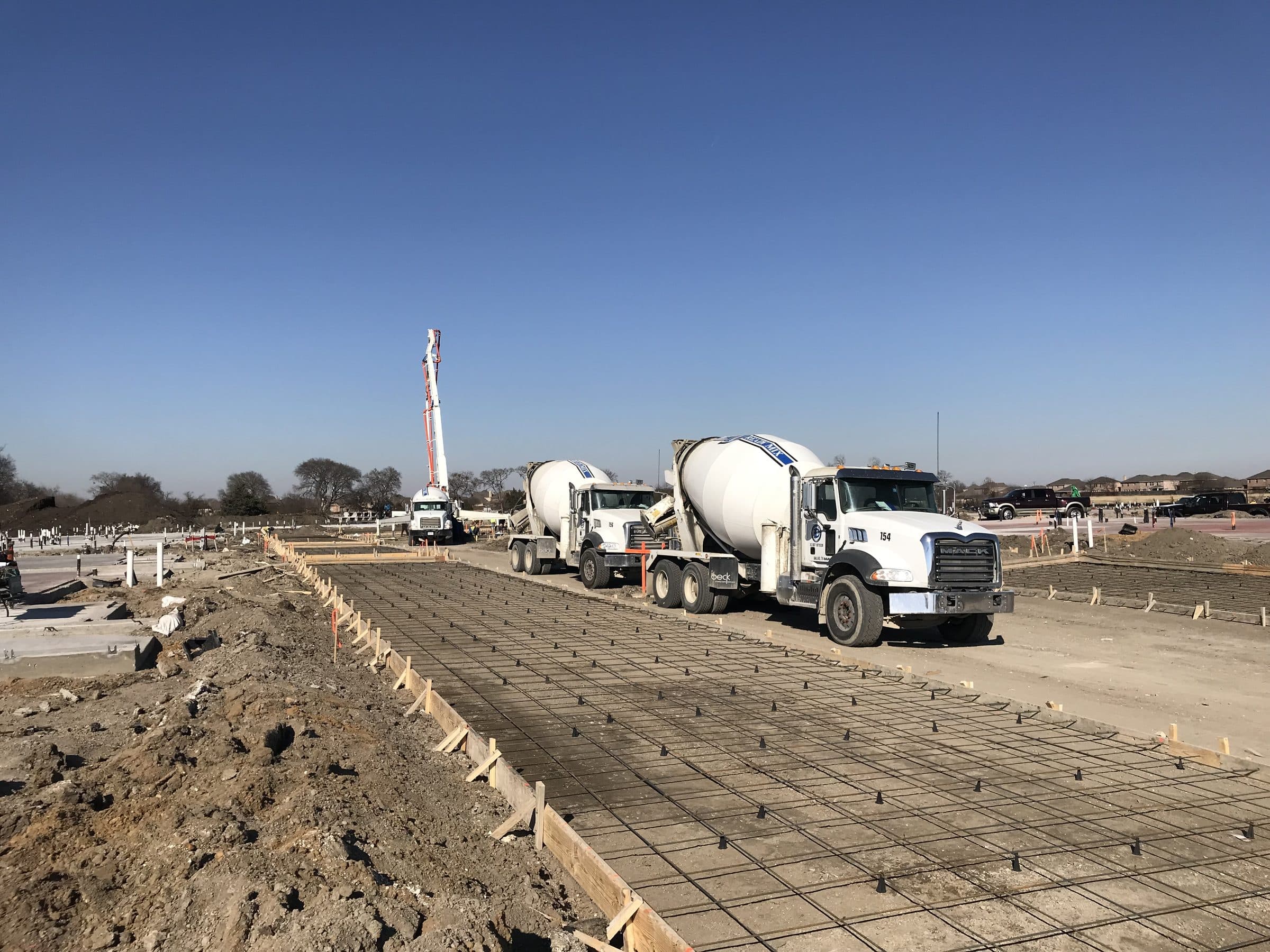 Ready-mix trucks alongside a formed and reinforced slab
