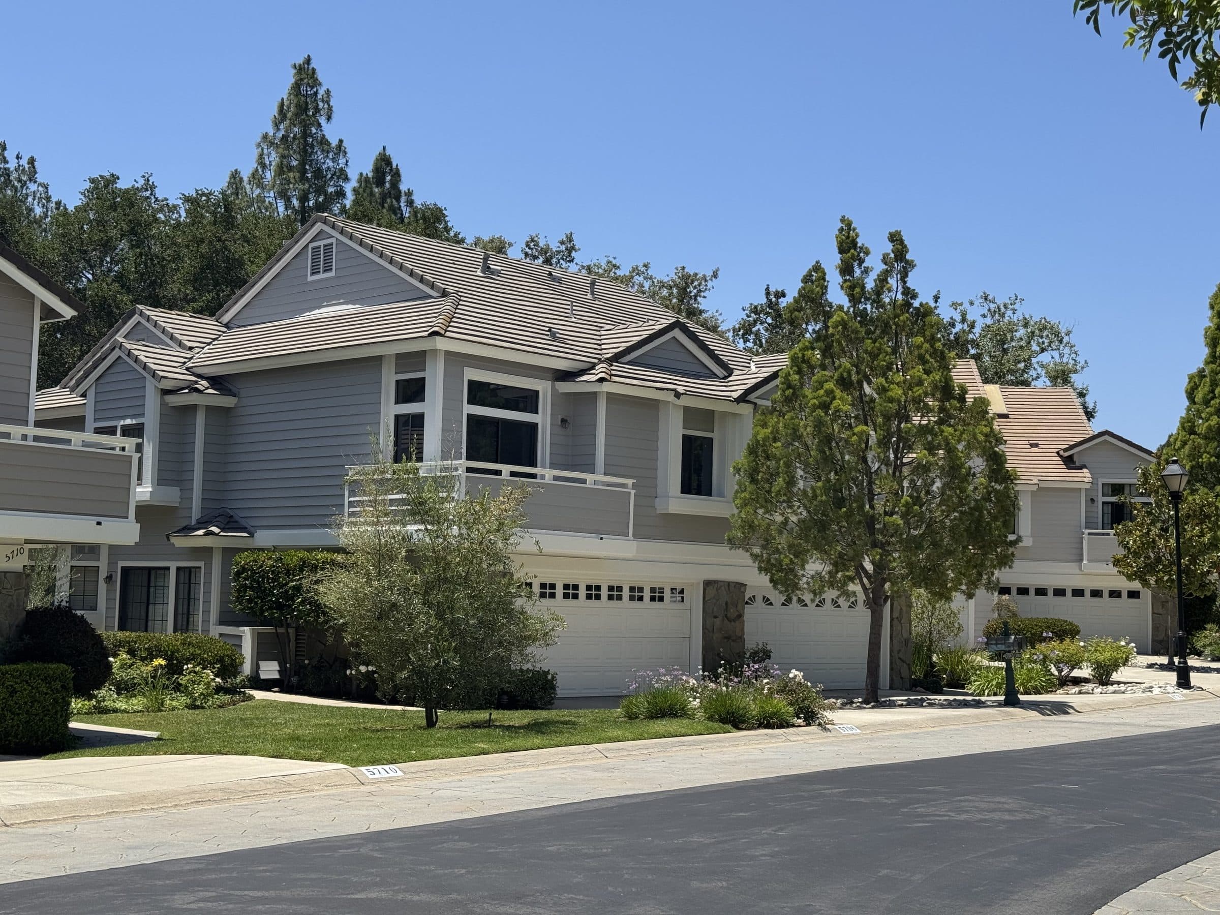 A gray-sided townhome building with balcony