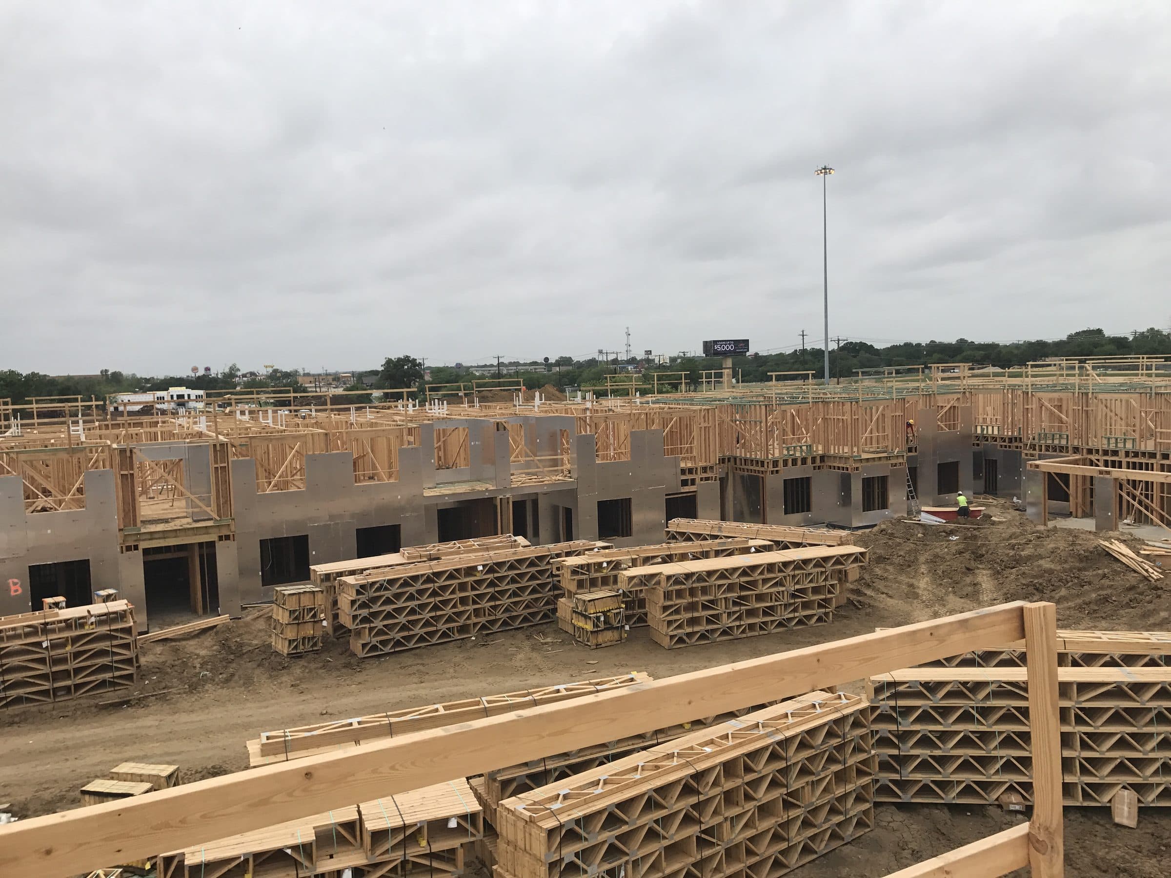 The construction site from above, framed walls and stacked roof trusses